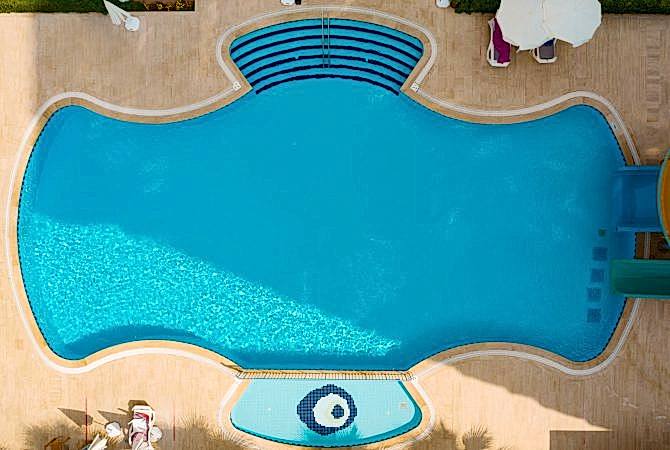 Aerial view of swimming pool outside hotel. Beautiful pool ready to holiday tourists.